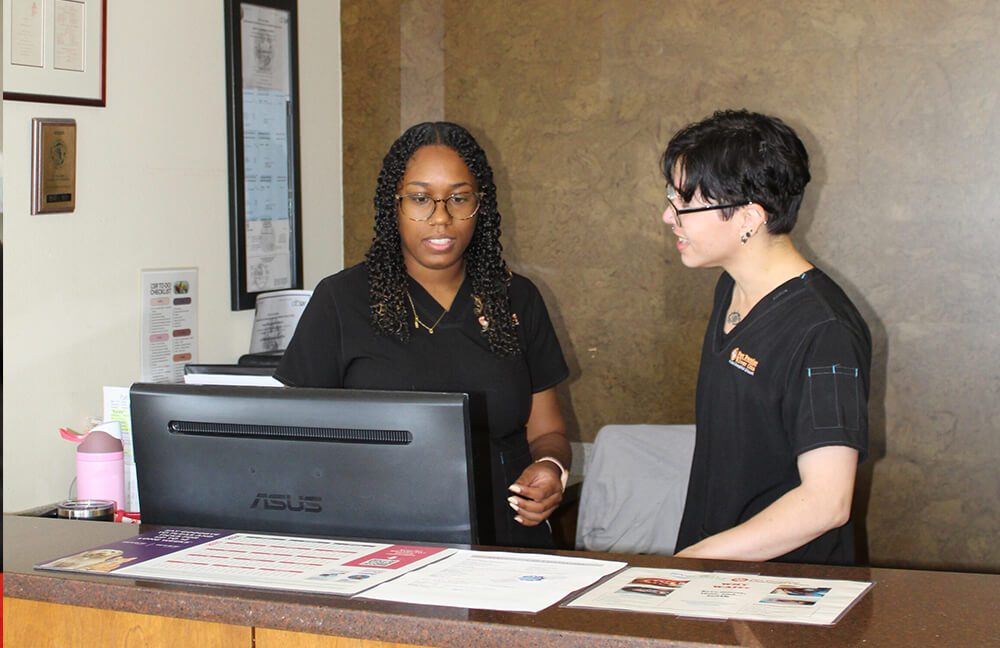 Staff At Reception two vet staff members at the reception counter by computer