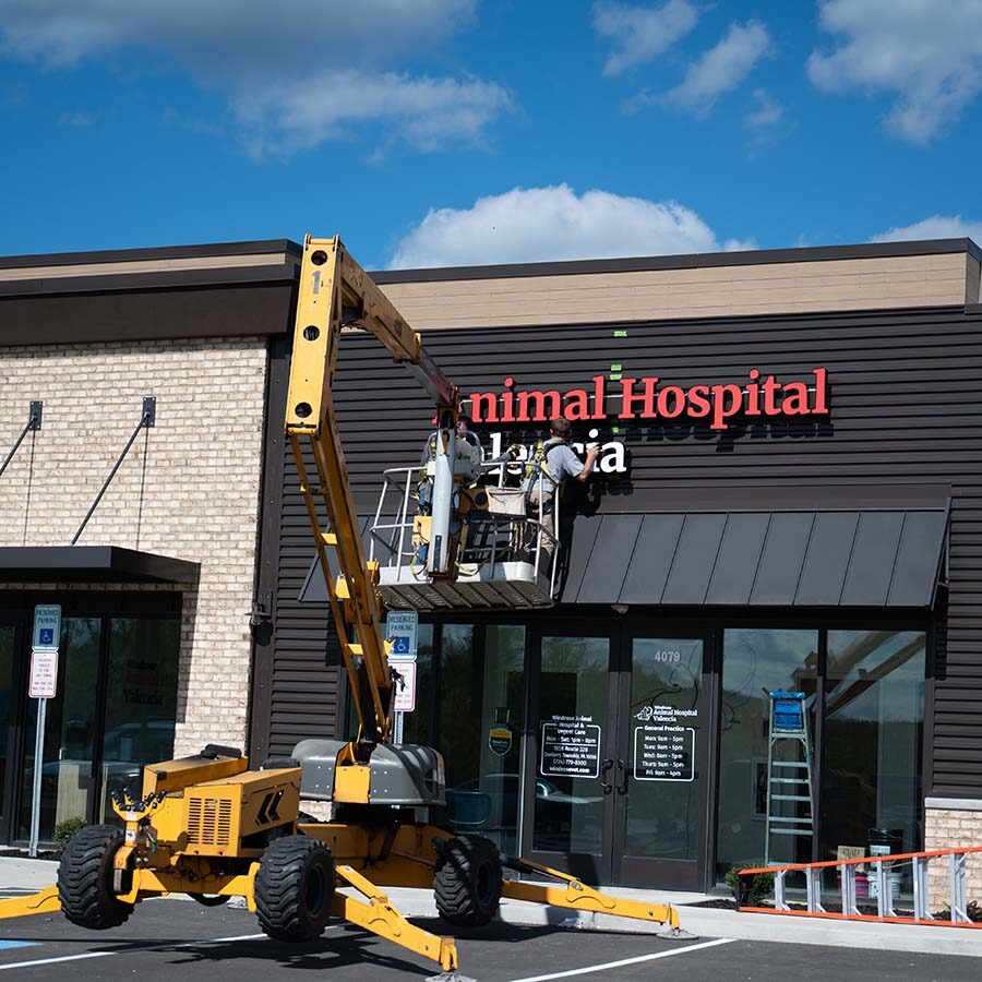 workers putting up the exterior sign at animal hospital of valencia