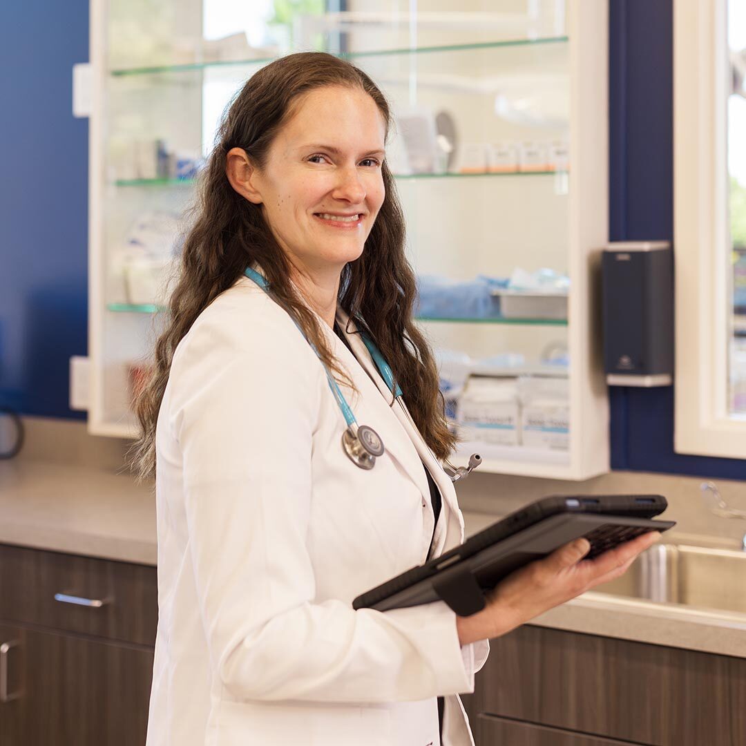 veterinarian holding tablet and smiling at the camera